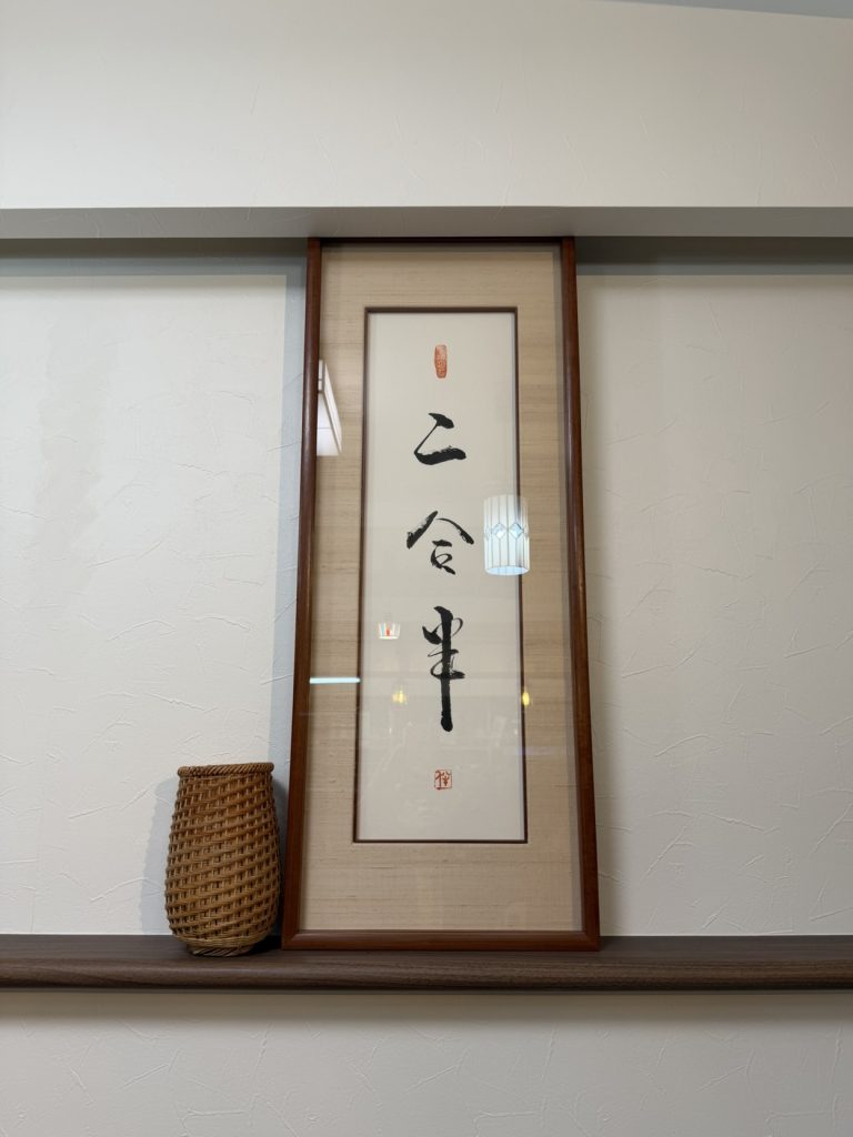 床の間に飾られた「二合半」の書の額